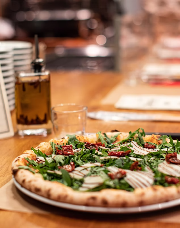 Pizza garnie de roquette et de tomates séchées
