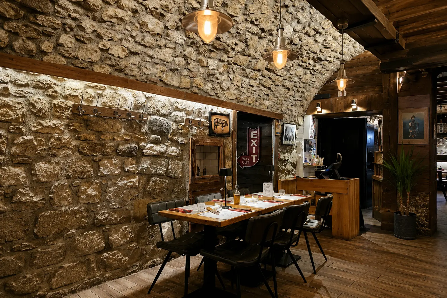 Salle chaleureuse du restaurant avec murs en pierre, tables en bois et suspensions vintage